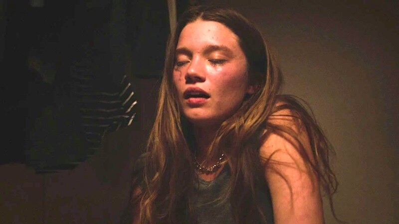 Primer plano de una mujer joven con los ojos cerrados y la boca abierta en actitud de shock o sorpresa
