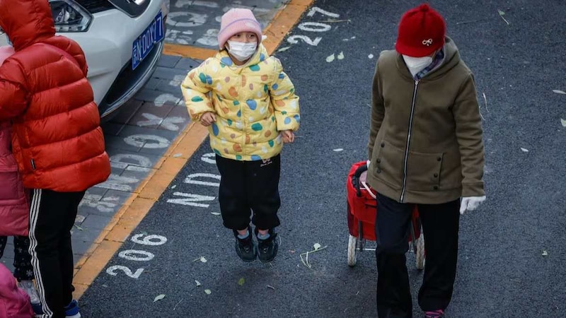 Una niña con mascarilla camina por la calle