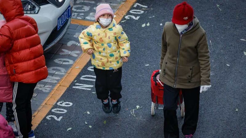 Una niña con mascarilla camina por la calle
