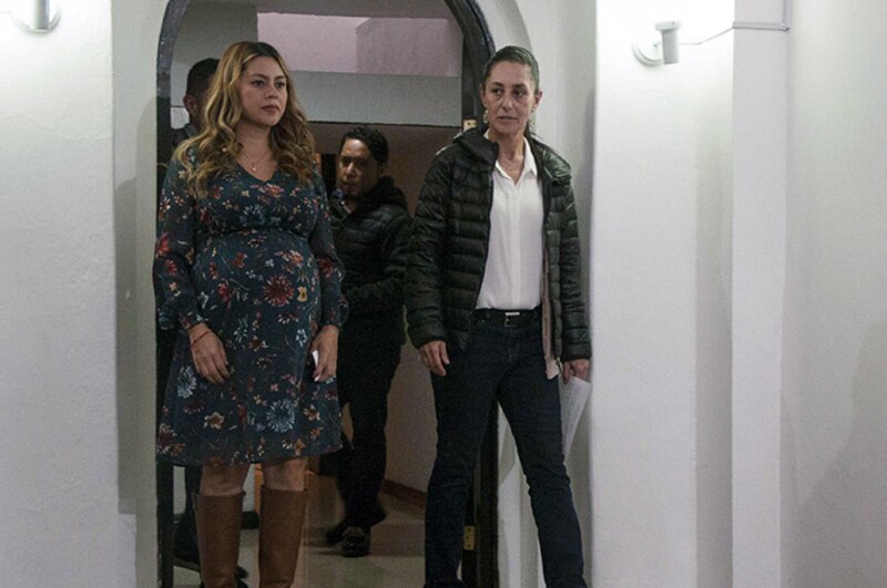 AMLO y su esposa Beatriz Gutiérrez Müller caminan por un pasillo