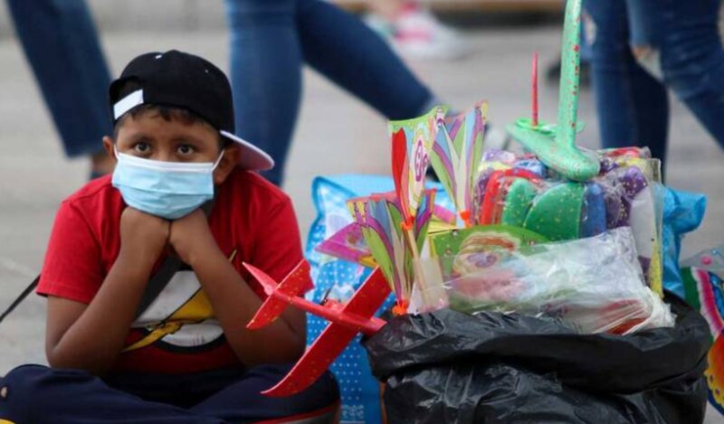 Niño vendedor ambulante con tapabocas