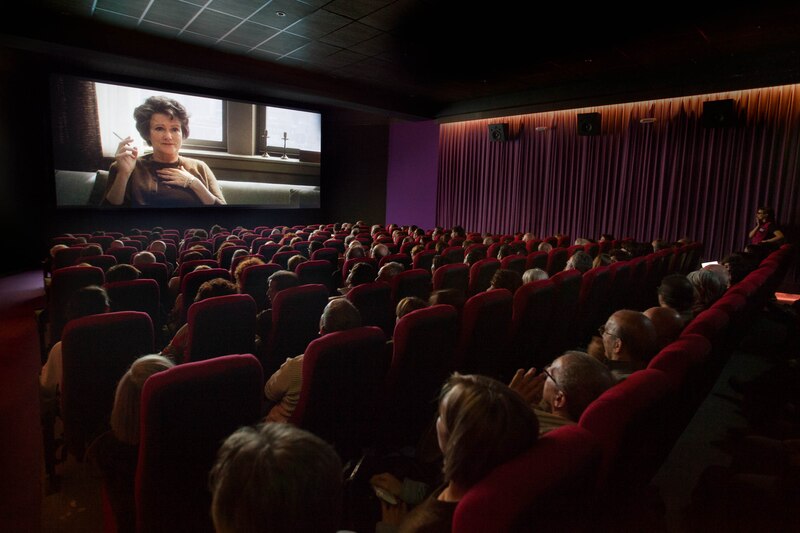 Una mujer ve una película en el cine