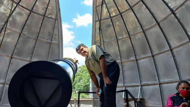 Un astrónomo observa el cielo a través de un telescopio.