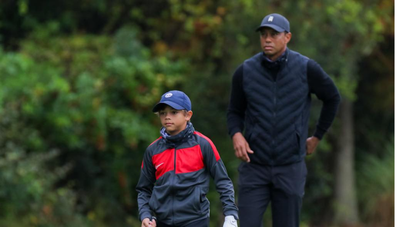 Tiger Woods y su hijo Charlie Woods caminan por el campo de golf.