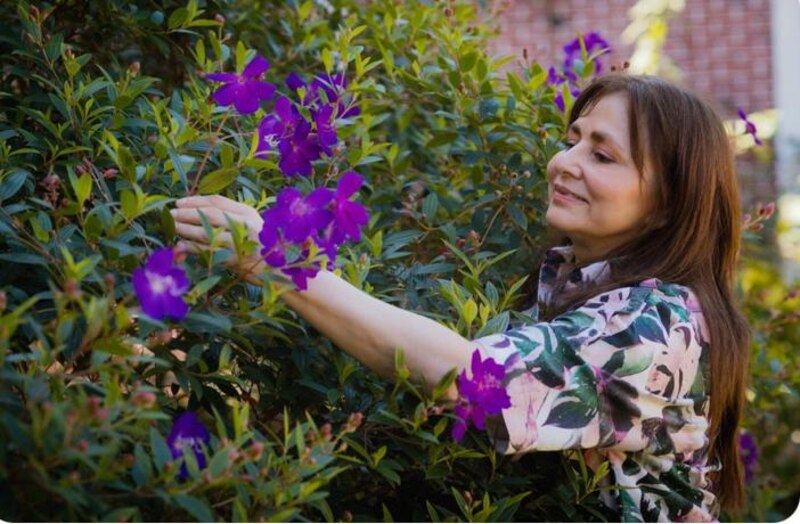 Mujer tocando las flores en el jardín