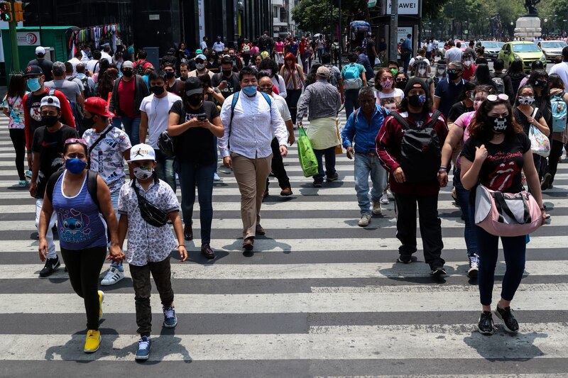 Multitud de personas cruza una calle en el centro de la Ciudad de México