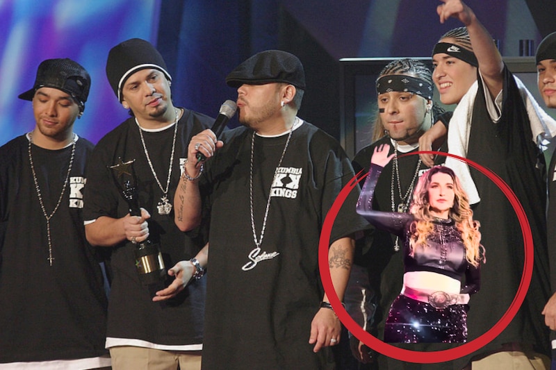Alicia Villarreal en un concierto, vestida de negro, haciendo la señal de auxilio por violencia de género, con los Kmbia Kings de fondo