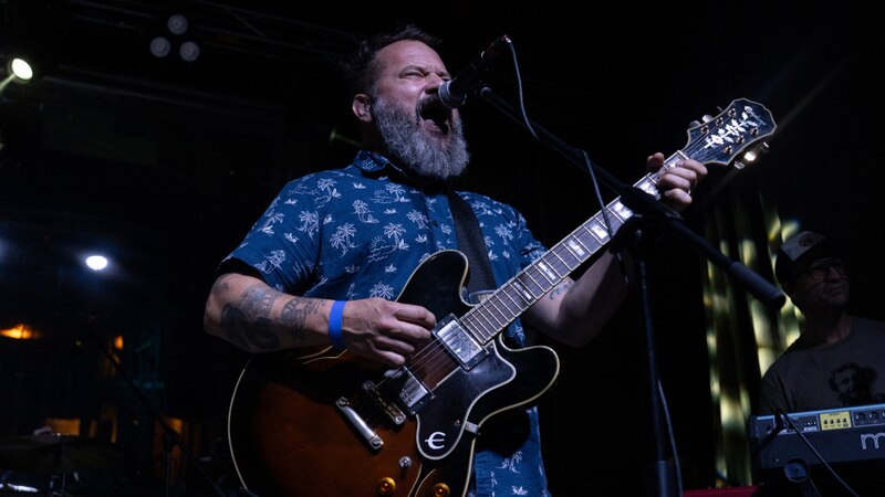 Cantante tocando la guitarra en un concierto