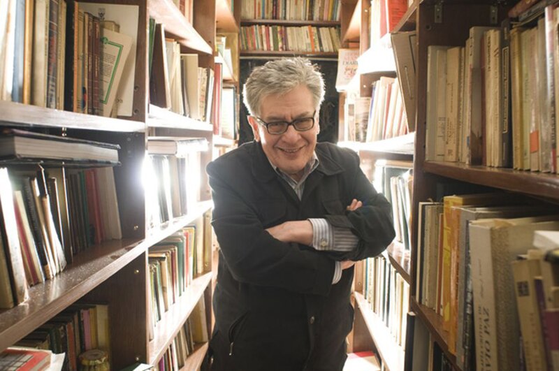 El escritor Salman Rushdie sonríe en una biblioteca