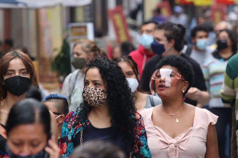 Multitud de personas con mascarillas en la calle