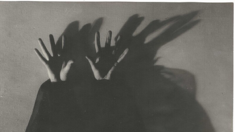 Manos que proyectan sombras en la pared
