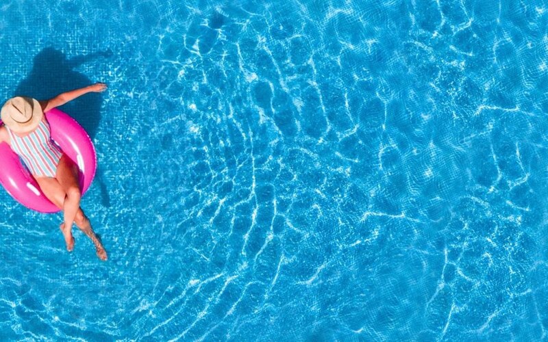 Mujer en traje de baño flotando en una piscina
