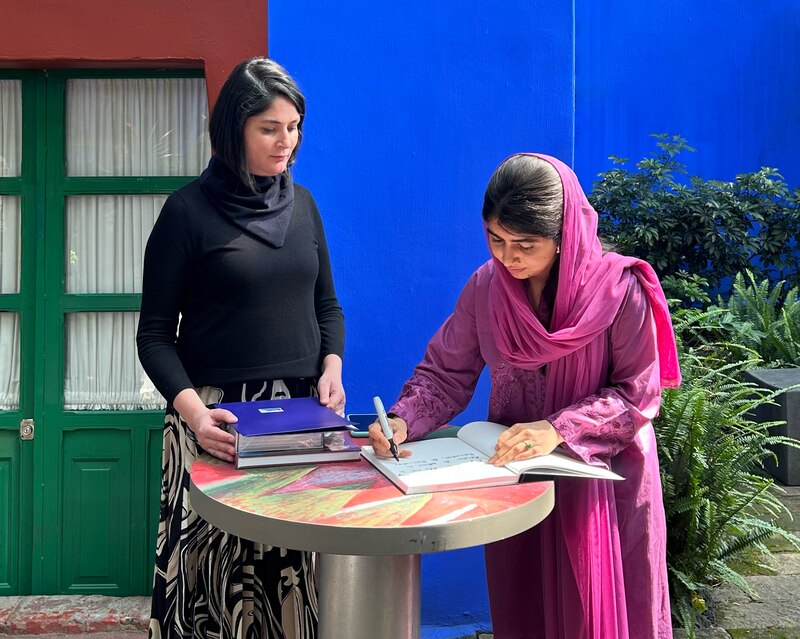 Malala firma el libro de visitantes de La Casa Azul, dejando un mensaje sobre la inspiración de Frida.