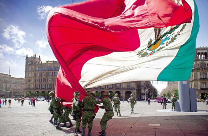 Soldados mexicanos ondeando la bandera nacional