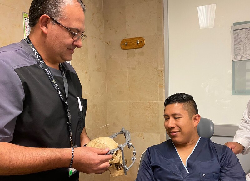 Un médico muestra un cráneo humano a un paciente.