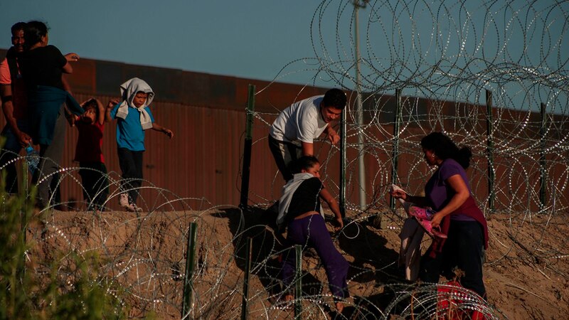 Familias migrantes cruzan la frontera entre México y Estados Unidos