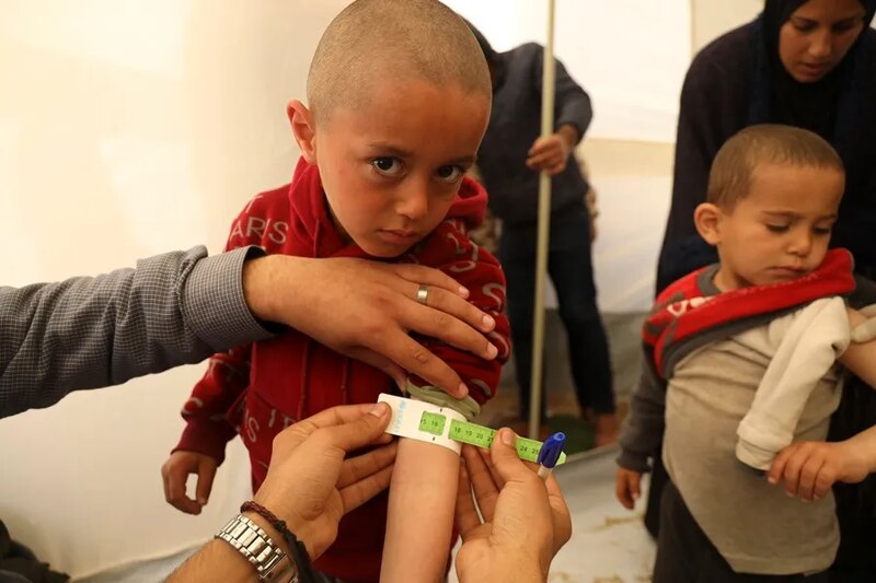 Un niño sirio es vacunado en un campo de refugiados.