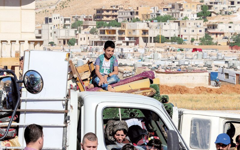 Niño sirio sentado en un camión en un campo de refugiados