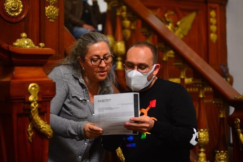 Dos personas leyendo un documento en una biblioteca