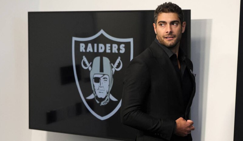 El jugador de fútbol americano Derek Carr posa para una foto con el logo de los Raiders de Las Vegas.
