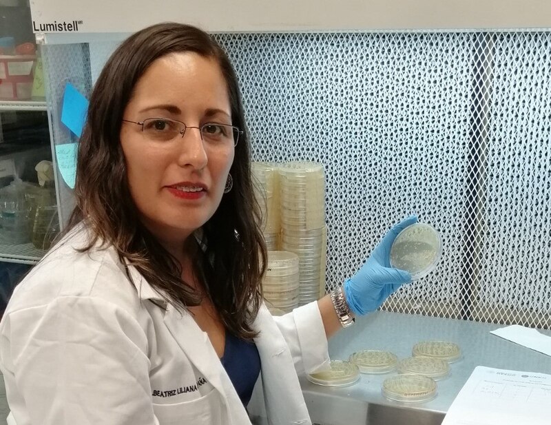 Científica sosteniendo una placa de Petri con bacterias
