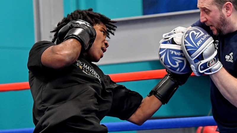 Joven boxeador entrenando con su entrenador