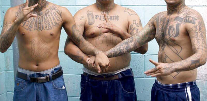 Tres hombres con tatuajes de pandillas