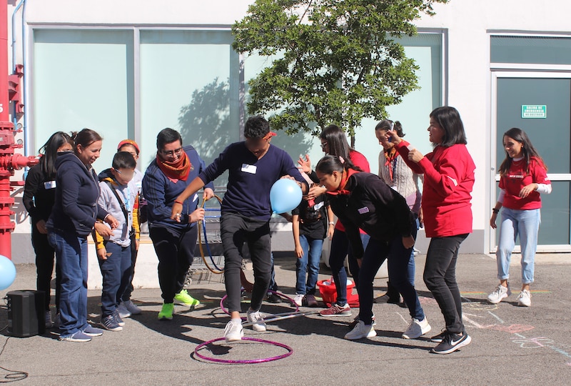 Jóvenes jugando con globos y aros en una actividad recreativa.