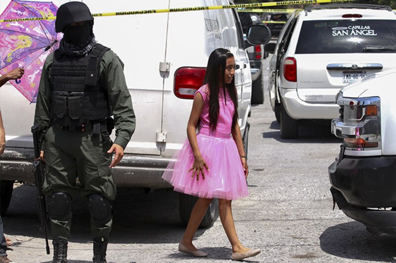 Niña camina sola en medio de policías y vehículos policiales