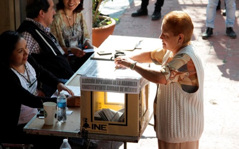 Mujer deposita su voto en una urna durante las elecciones en México