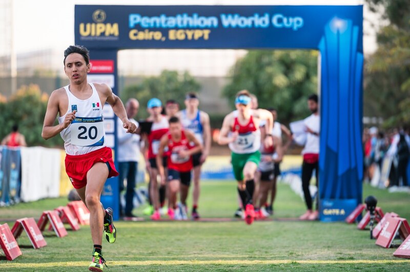 Atletas corriendo en una competencia de pentatlón moderno.
