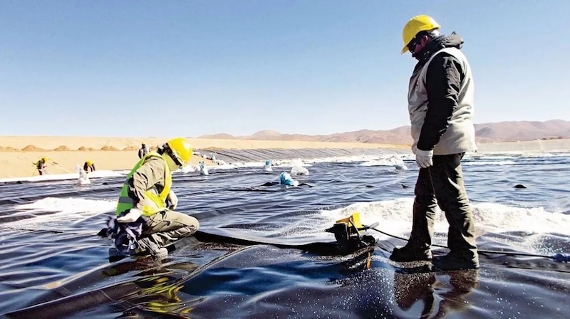 Trabajadores instalando un geomembrana en un depósito de relaves mineros