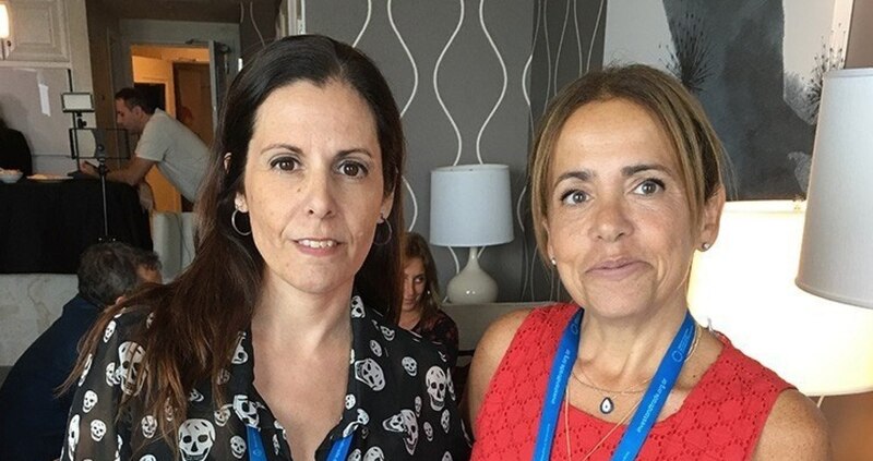 Dos mujeres sonríen en una habitación