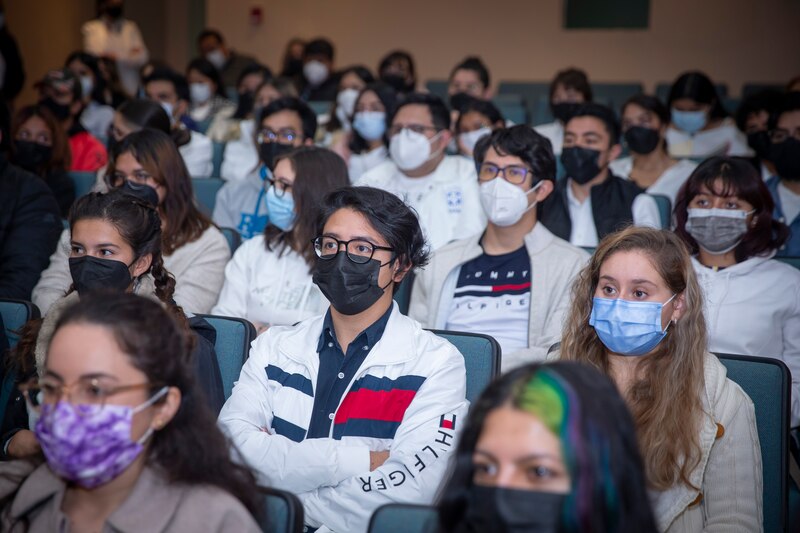 Estudiantes universitarios con mascarillas en una conferencia