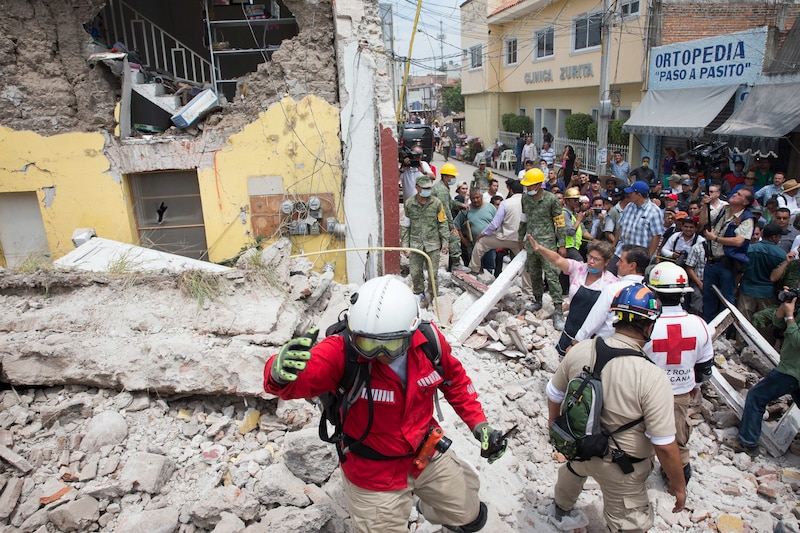 Rescatistas buscan sobrevivientes entre los escombros de un edificio colapsado