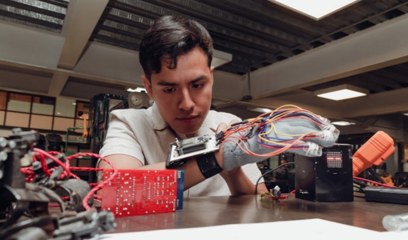 Un joven ingeniero trabaja en un proyecto de robótica.