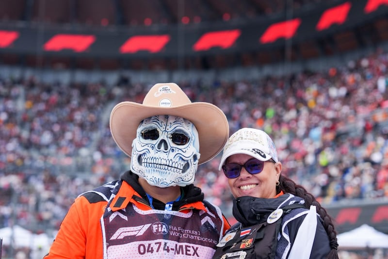 Auxiliares del Gran Premio de la Ciudad de México de la Fórmula 1 posan tras el desfile de pilotos en las inmediaciones del Autódromo Hermanos Rodríguez