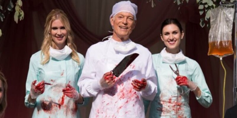Un posible título para esta imagen podría ser "Tres cirujanos sonríen cubiertos de sangre".