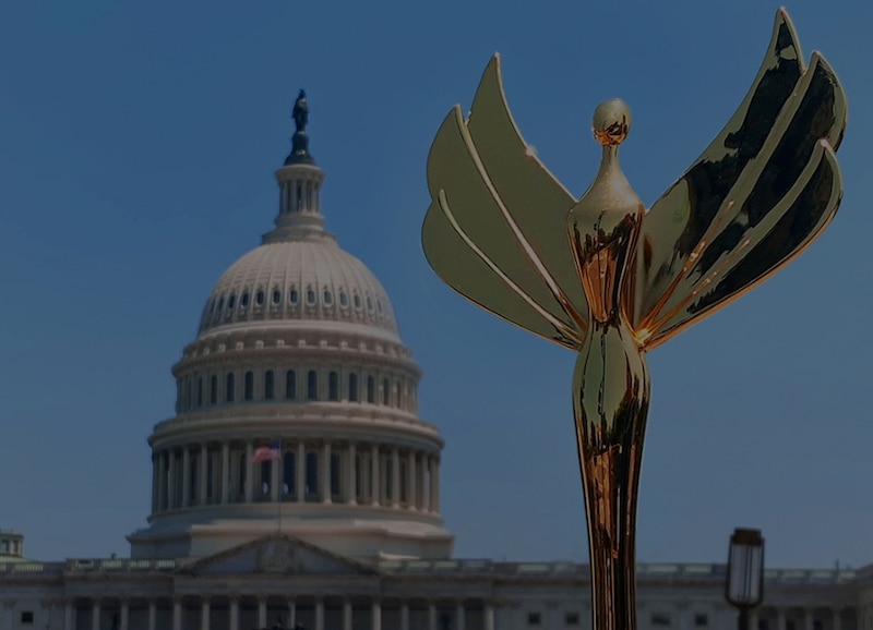 Estatua dorada de la mujer alada con el Capitolio de los Estados Unidos al fondo