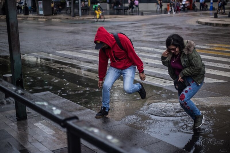 Jóvenes saltando en los charcos de la lluvia