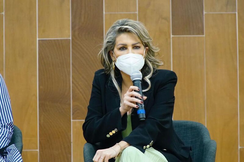 La periodista María Teresa Pérez entrevista a una mujer en un foro sobre el cambio climático.