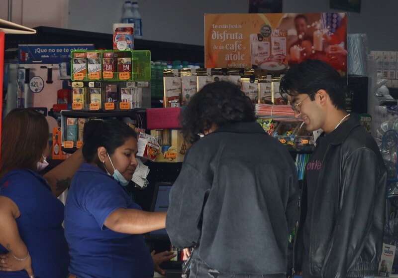 Title: Joven paga en efectivo en una tienda