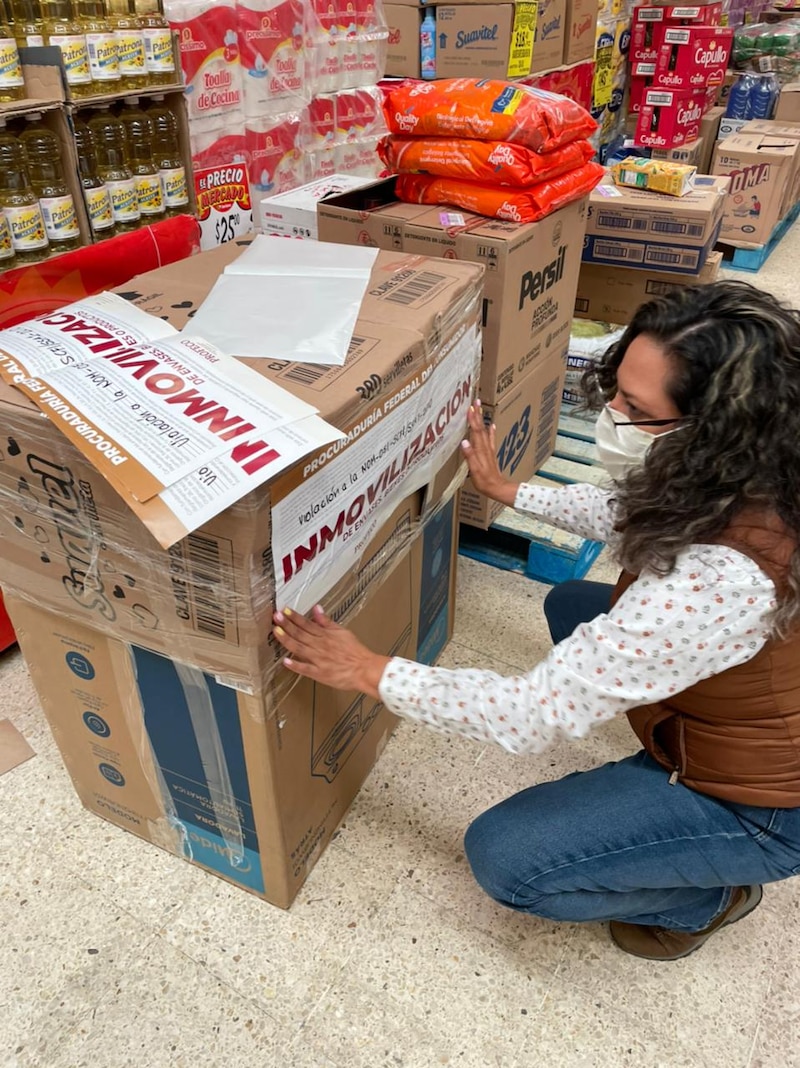 Mujer colocando un letrero en una caja de cartón en un supermercado
