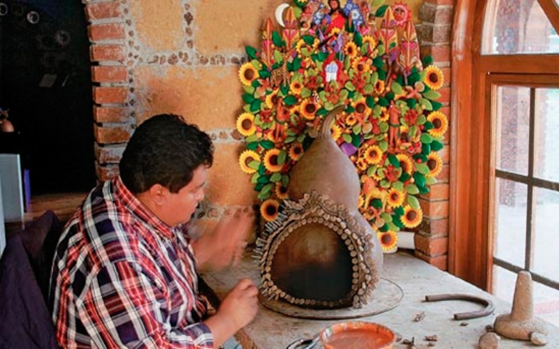 Artesano mexicano trabajando en una artesanía de barro