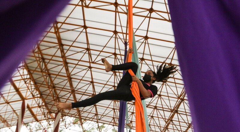Mujer joven haciendo acrobacias en telas aéreas