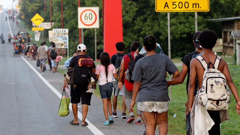 Migrantes venezolanos caminan por una carretera en busca de un nuevo hogar