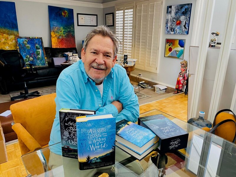 El autor Benjamin Alire Sáenz posa junto a sus libros.