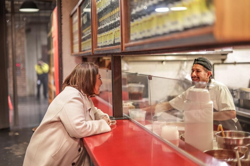 Cocinero y clienta sonríen en un restaurante