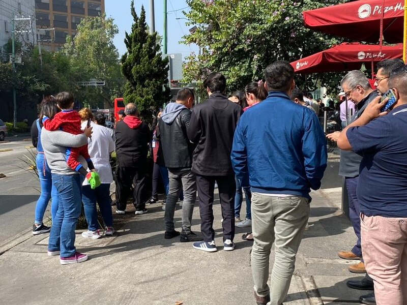Larga fila de personas esperando para entrar a un restaurante