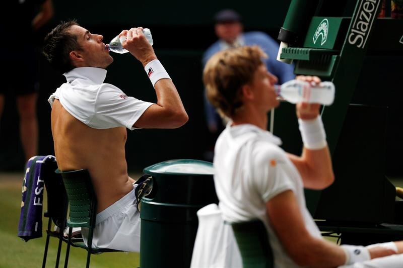 Dos tenistas bebiendo agua durante un partido